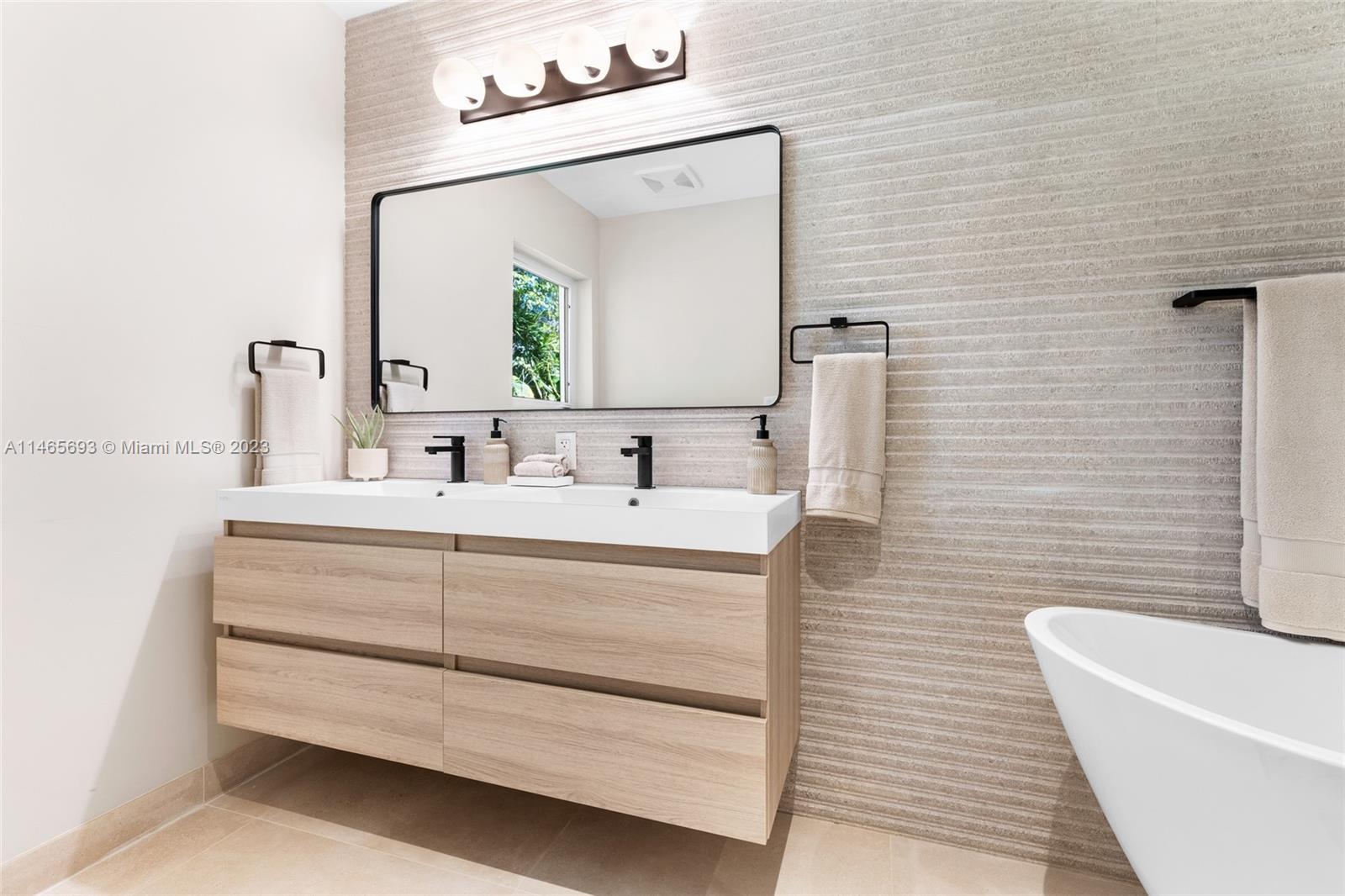 4160 Alton Road Miami Beach, FL 33140 - Photo 14 of 34 a bathroom with a sink and a mirror