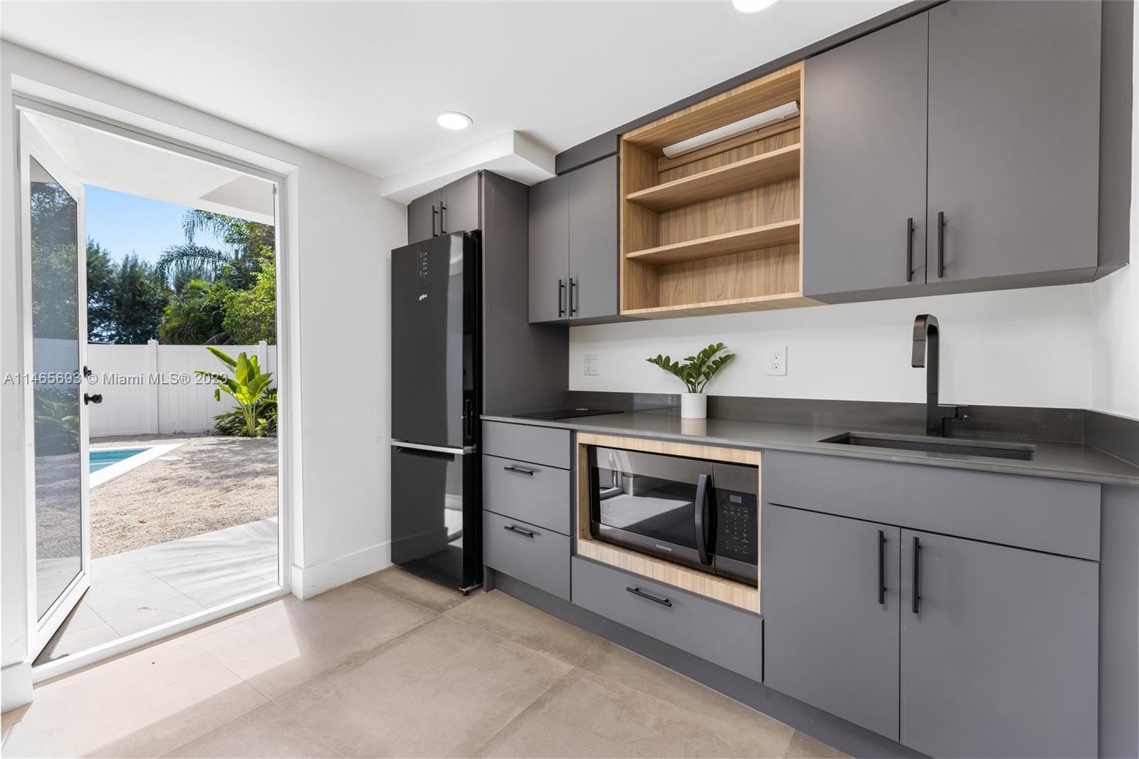 4160 Alton Road Miami Beach, FL 33140 - Photo 25 of 34 a kitchen with stainless steel appliances granite countertop a refrigerator sink and stove
