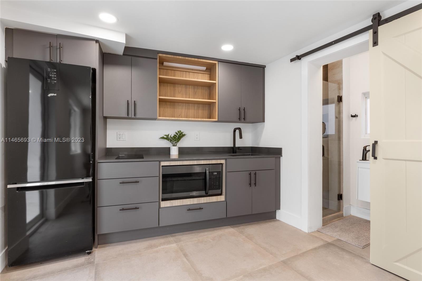 4160 Alton Road Miami Beach, FL 33140 - Photo 29 of 34 a kitchen with stainless steel appliances granite countertop a refrigerator and a sink