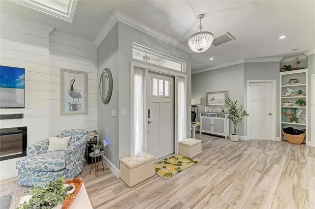 a living room with furniture a fireplace and a chandelier