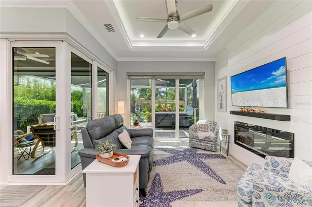 a living room with stainless steel appliances granite countertop furniture wooden floor and a large window