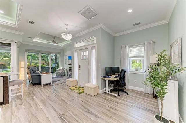 a living room with furniture a flat screen tv and floor to ceiling window