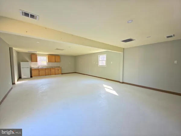 a view of an empty room with a kitchen