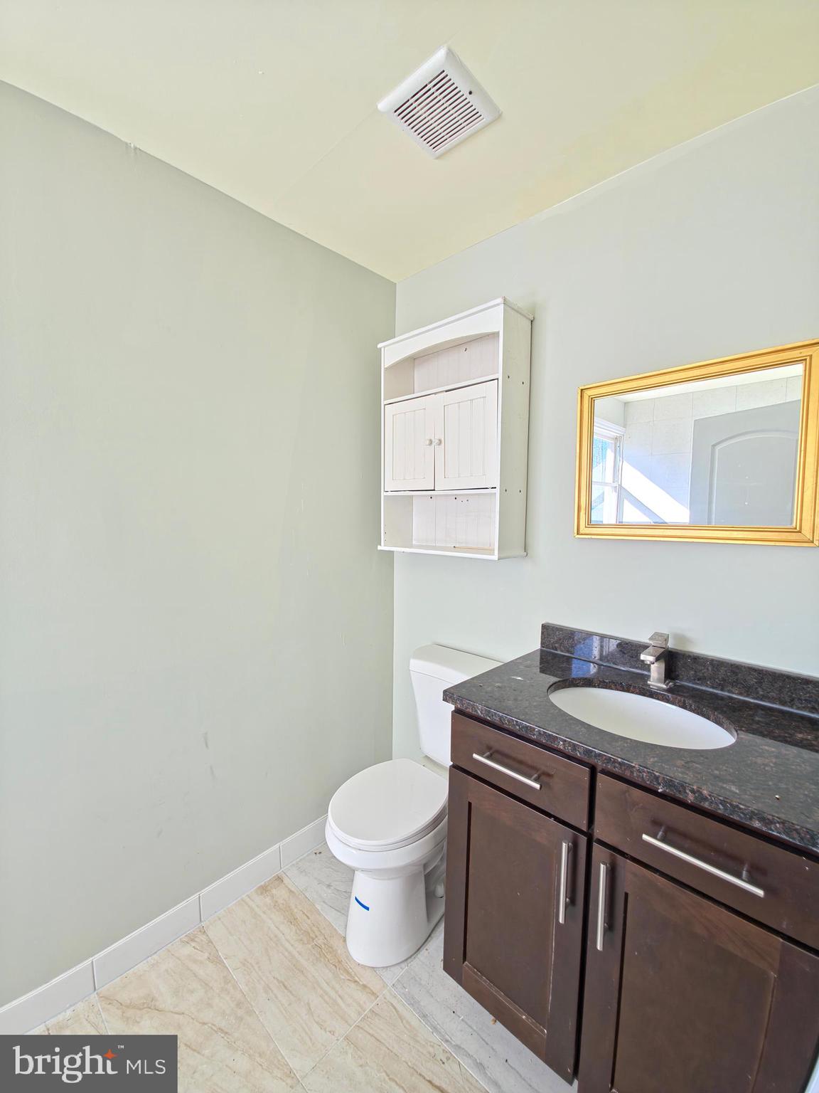 7450 Bensville Road Waldorf, MD 20603 - Photo 29 of 41 a bathroom with a granite countertop sink a toilet and a mirror