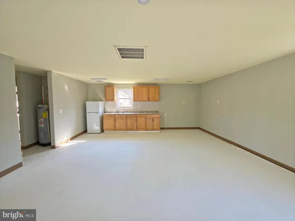 a view of empty room with a kitchen