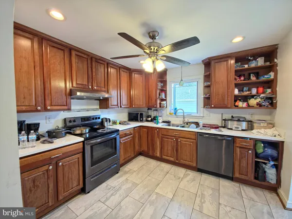 a kitchen with stainless steel appliances granite countertop a stove sink and cabinets