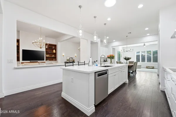 a kitchen with stainless steel appliances a refrigerator sink and wooden floor
