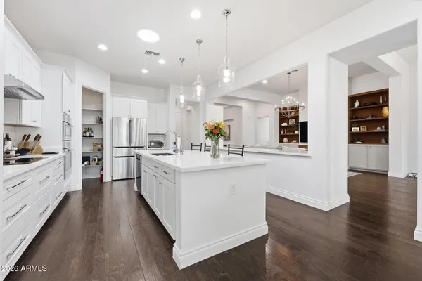 a view of an empty room with wooden floor and a mirror