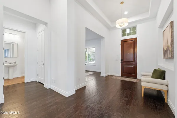 a view of a big room with wooden floor windows and a chandelier