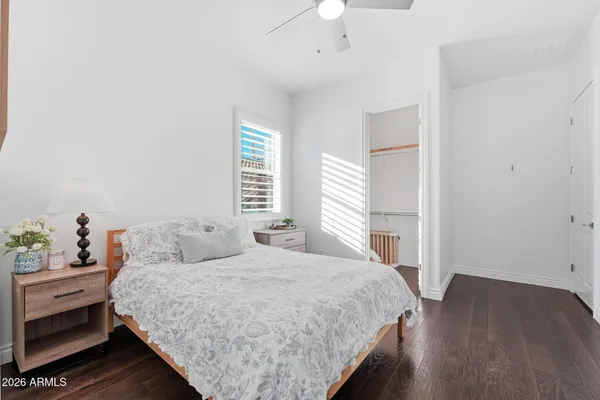 an empty room with wooden floor and a ceiling fan