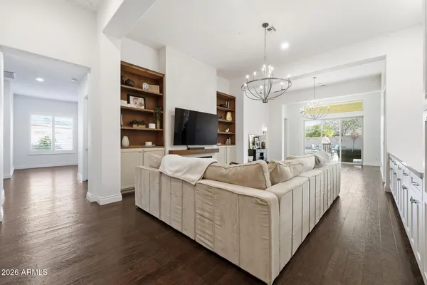 a large white kitchen with stainless steel appliances kitchen island a large counter top and a wooden floors