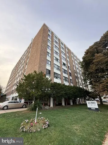 a view of a building with a big yard and large trees