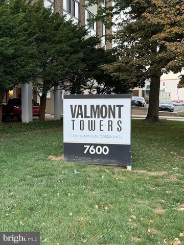 a sign of golf club on a wall under a tree