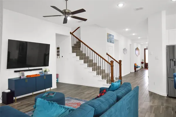 a living room with furniture kitchen view and a flat screen tv