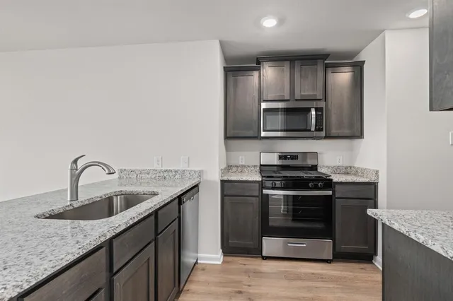 a kitchen with granite countertop a sink and steel appliances