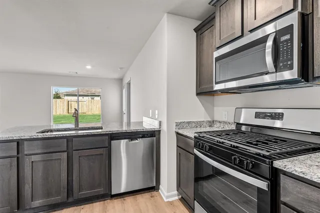 a kitchen with granite countertop stainless steel appliances and sink