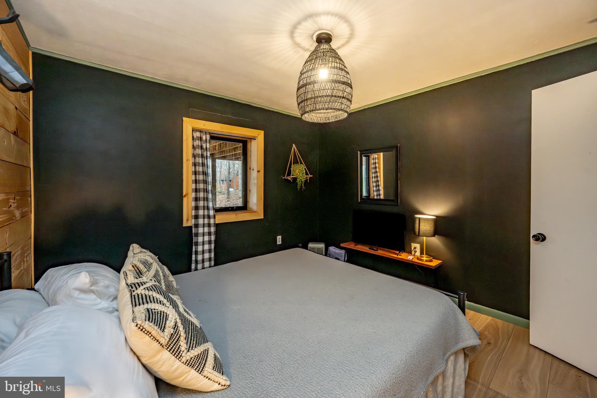527 Deer Run Lane Swanton, MD 21561 - Photo 42 of 51 a bedroom with a bed and a chandelier