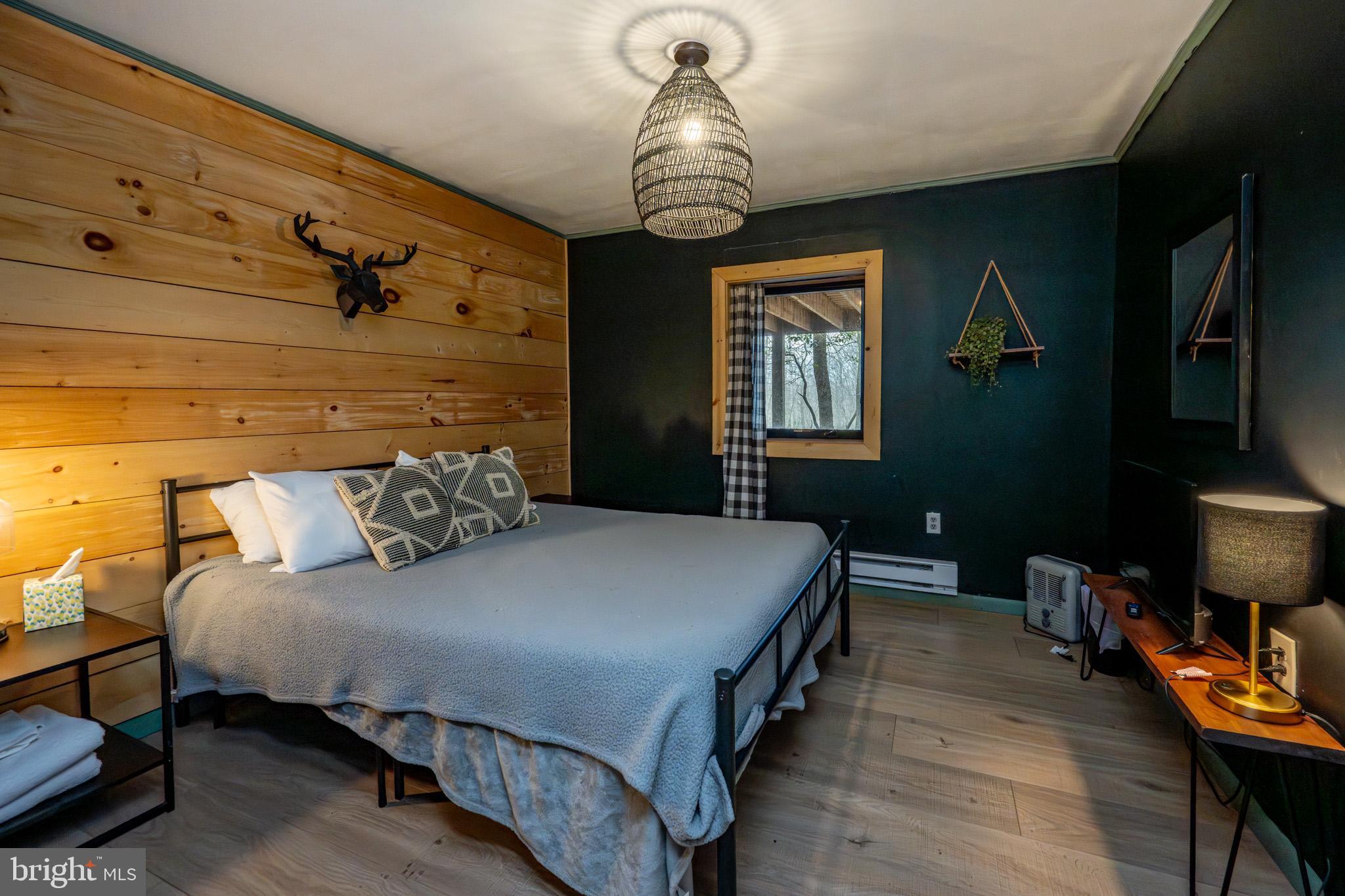 527 Deer Run Lane Swanton, MD 21561 - Photo 44 of 51 a bedroom with a bed and a chandelier