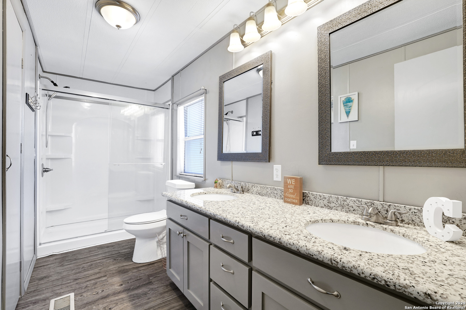 18066 La Gloria Road Elmendorf, TX 78112 - Photo 17 of 24 a bathroom with a granite countertop sink mirror vanity and toilet