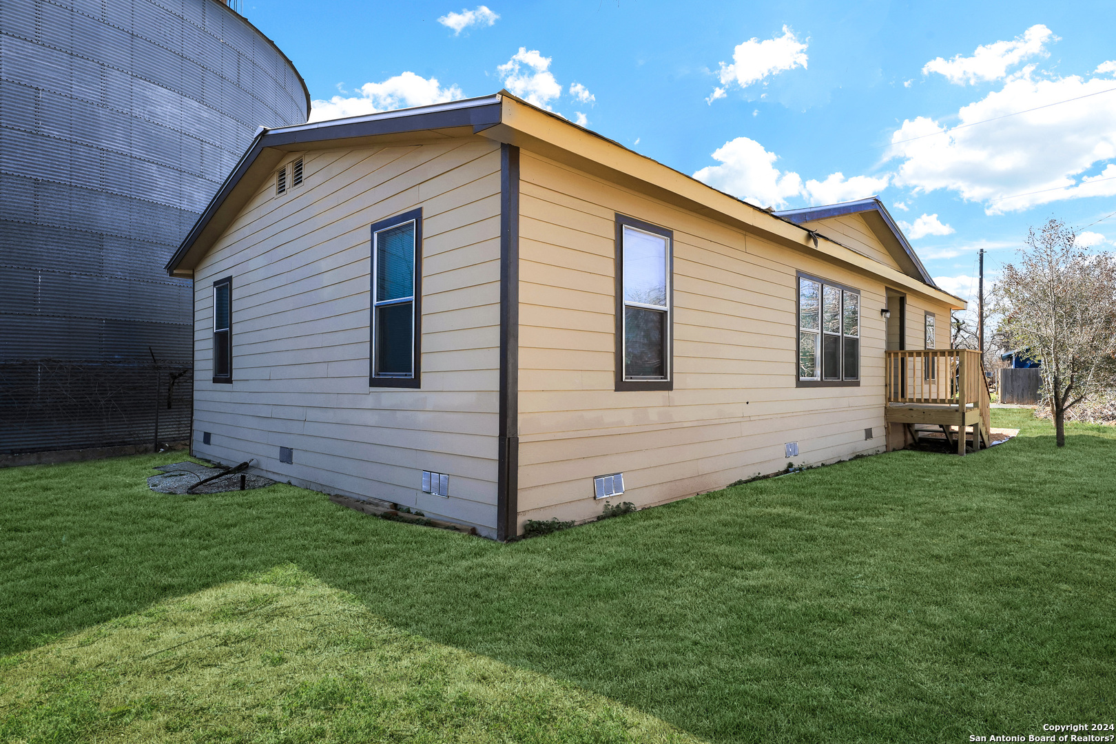 18066 La Gloria Road Elmendorf, TX 78112 - Photo 2 of 24 a front view of a house with a garden