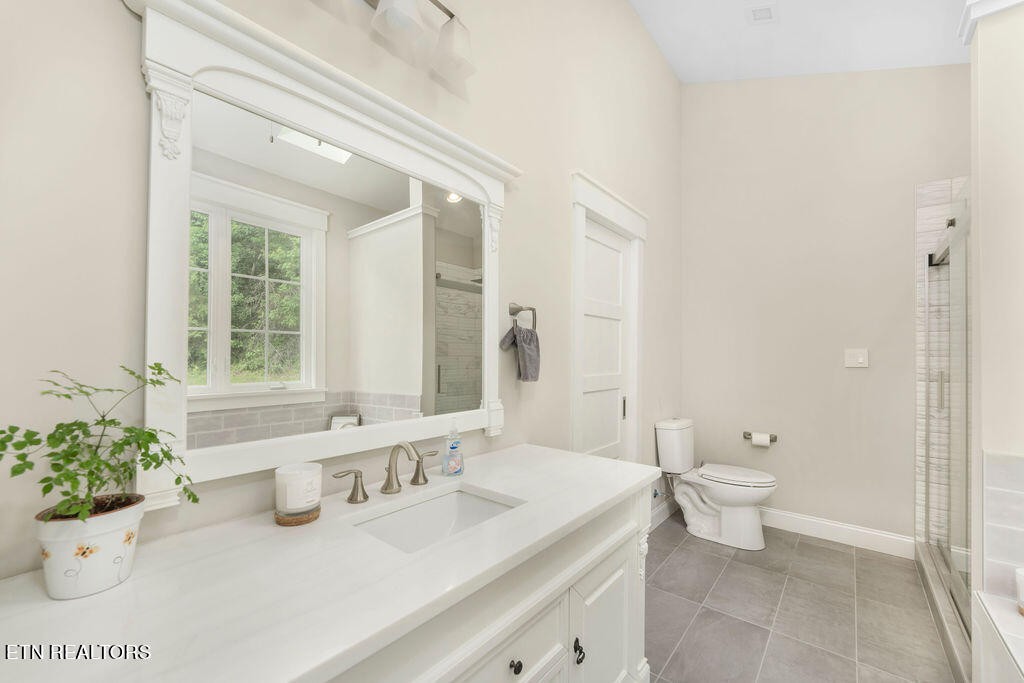9760 Chestnut Ridge Road Heiskell, TN 37754 - Photo 18 of 59 a bathroom with a granite countertop sink a large mirror a toilet and a shower