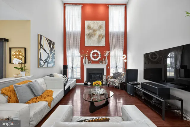 a kitchen with stainless steel appliances kitchen island granite countertop a refrigerator a stove a sink a dining table and chairs with wooden floor