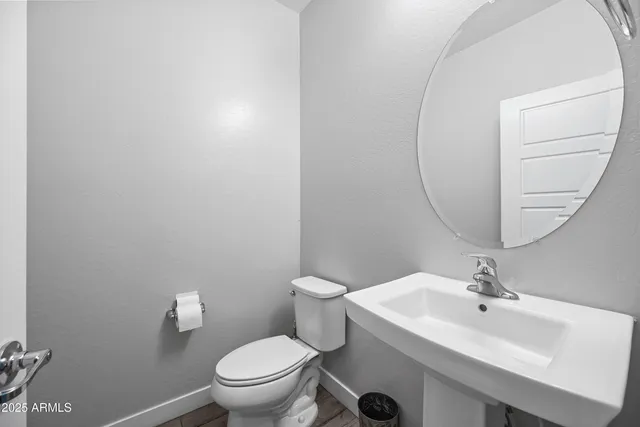 a bathroom with a sink a toilet and a mirror