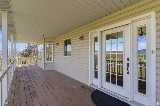 380 Luzern Road Midway, UT 84049 - Photo 7 of 74 Expansive covered porch with wood-finish flooring, white railing, and multiple support columns