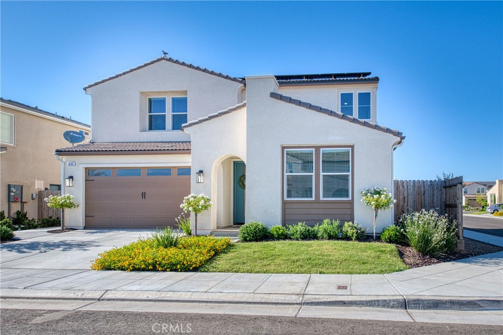 a front view of a house with a yard and potted plants