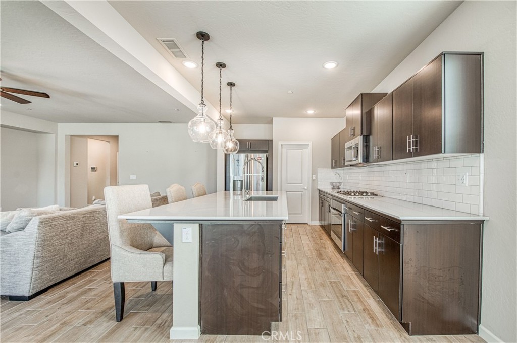 4135 Mecca Avenue Clovis, CA 93619 - Photo 14 of 32 a large white kitchen with a stove and a sink