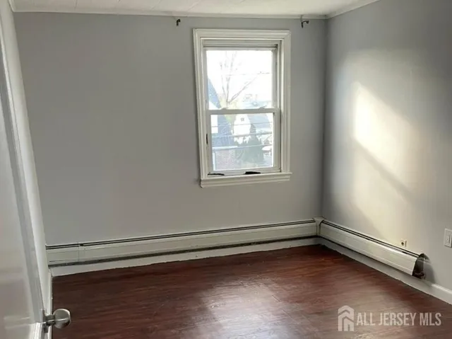 a view of a room with wooden floor and a window
