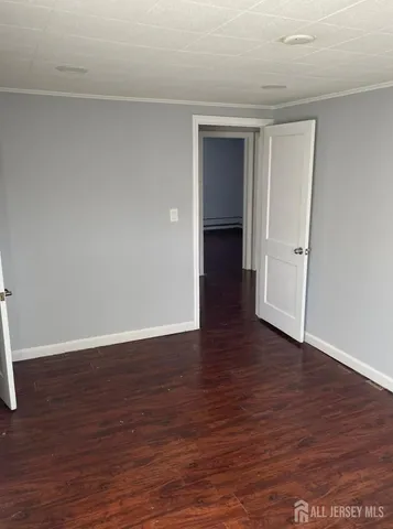 a view of an empty room and wooden floor and closet