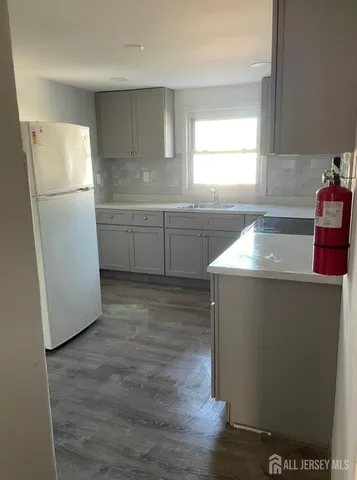 a kitchen with sink a refrigerator and window