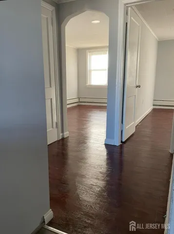 a view of a hallway with hardwood floor and a living room