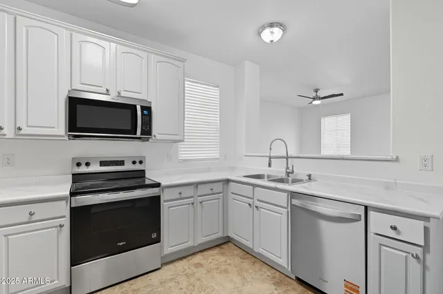 a kitchen with stainless steel appliances white cabinets and a stove top oven