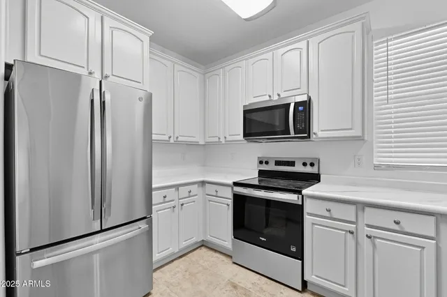 a view of kitchen with refrigerator and cabinet