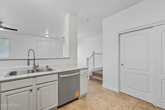 a kitchen with a sink stainless steel appliances and white cabinets