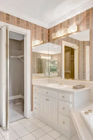 a kitchen with white cabinets and a window