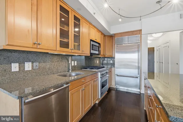 a kitchen with stainless steel appliances granite countertop a sink and cabinets