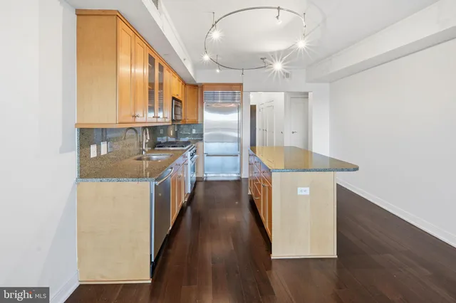 a kitchen with stainless steel appliances granite countertop a sink a stove and a refrigerator