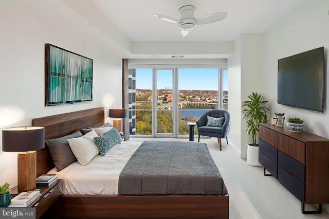 a bedroom with a large bed and a flat tv screen on dresser