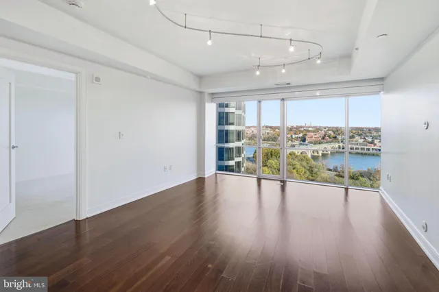 a view of empty room with wooden floor