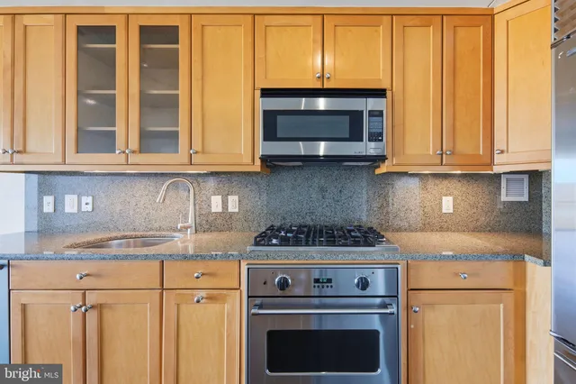 a kitchen with granite countertop cabinets stainless steel appliances and a sink