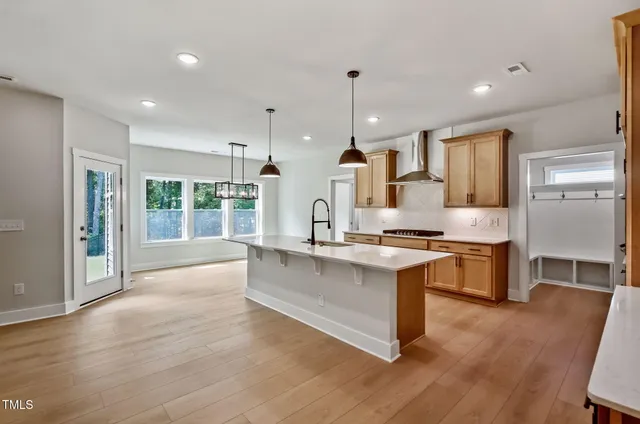a large kitchen with kitchen island a large counter top space a sink stainless steel appliances and cabinets