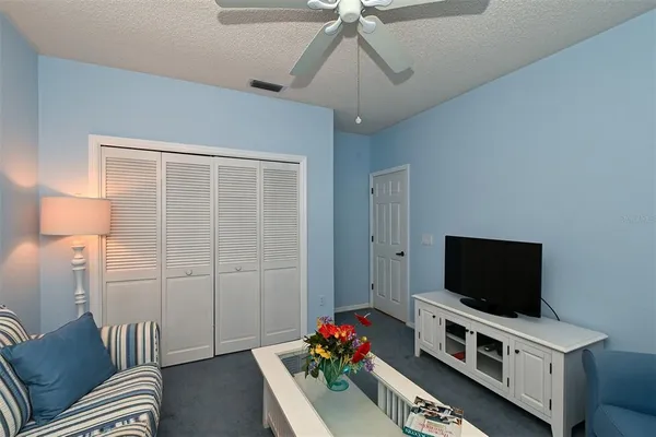 a utility room with a sink a clock and cabinets