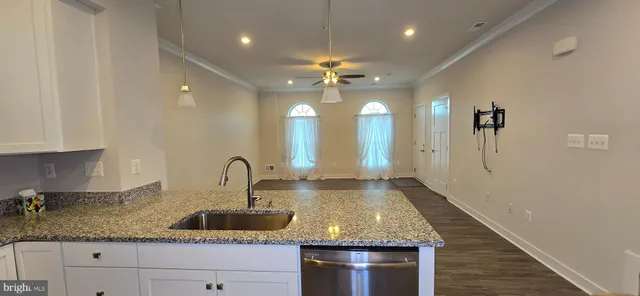 a kitchen with kitchen island granite countertop a sink stainless steel appliances and cabinets