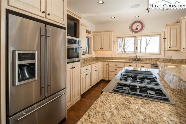a kitchen with stainless steel appliances a stove a sink and a refrigerator
