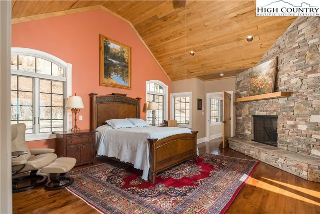 a spacious bedroom with a bed and wooden floor