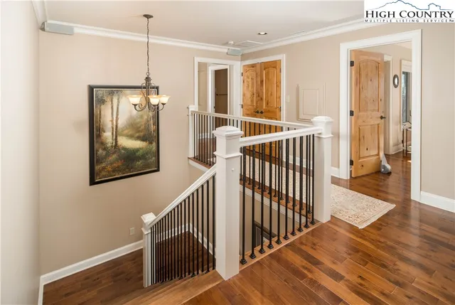a view of a hallway with wooden floor and door