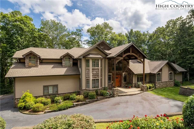 a view of a white house with large windows and a small yard